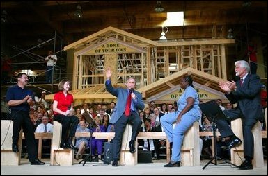 President George W. Bush acknowledges the audience at the conclusion of a conversation on homeownership at the Carpenters Training Center in Phoenix, Ariz., Friday, March 26, 2004. Pictured on stage with the President, from left, are construction foreman Jorge Sotelo, first-time homebuyer Emily McElhaney, first-time homebuyer Monica Sims and Doug McCarron, General President of the United Brotherhood of Carpenters and Joiners of America. White House photo by Eric Draper